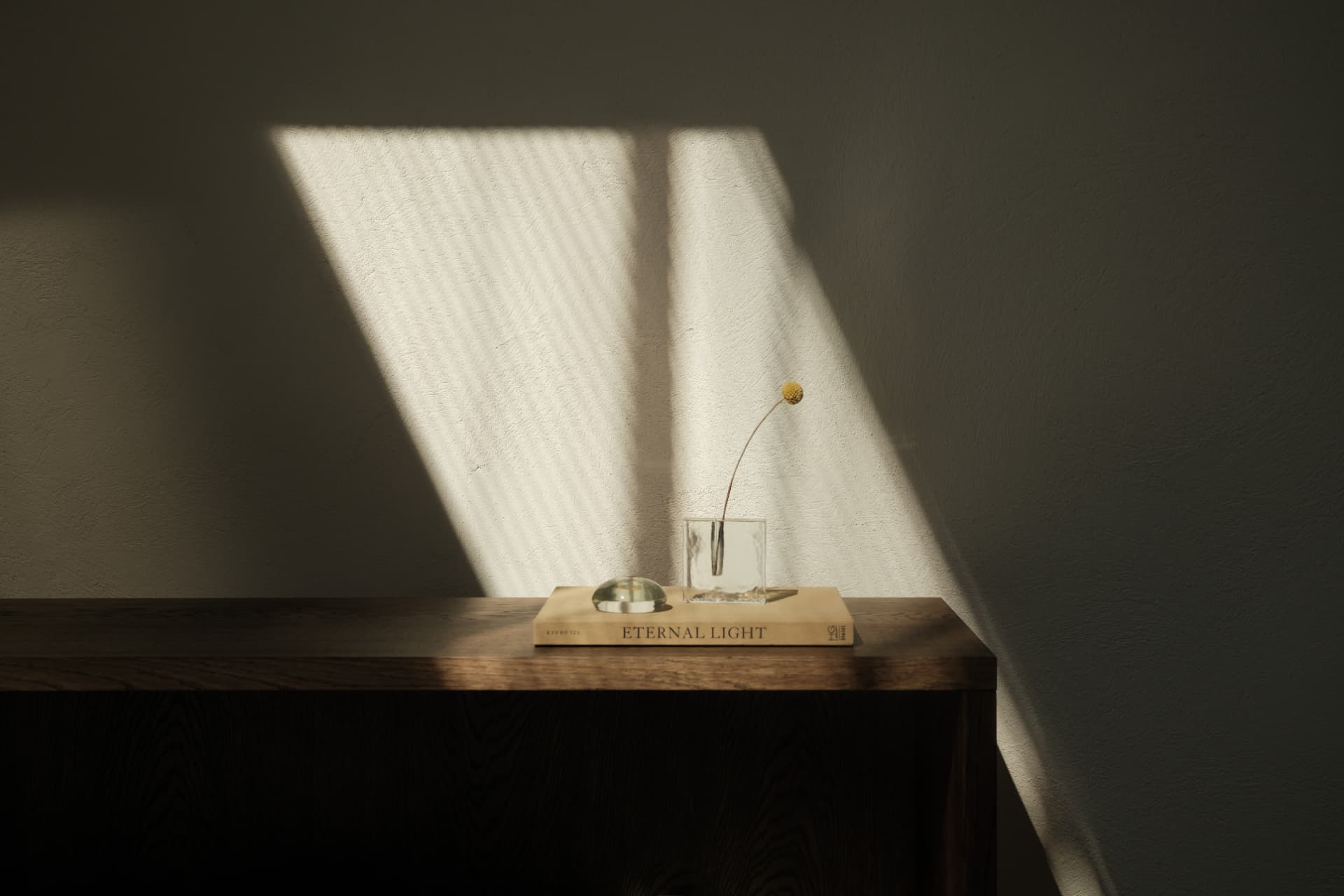 Dark wood console with a glass vase in sunlight